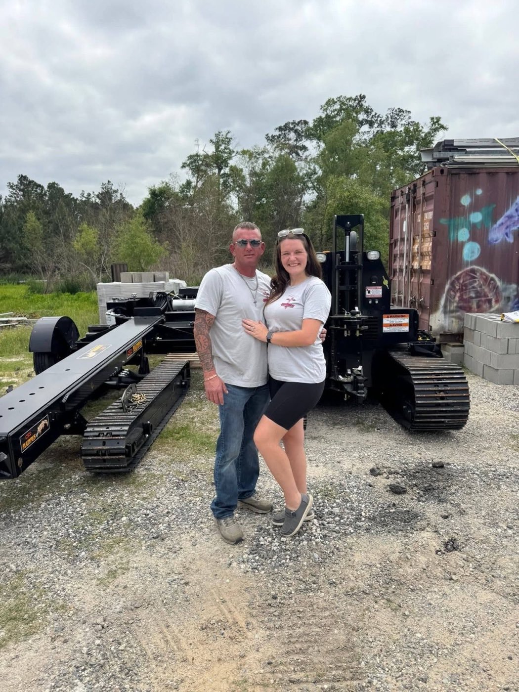 The owners of Green Mobile Home Transport standing in front of their mobile home moving equipment